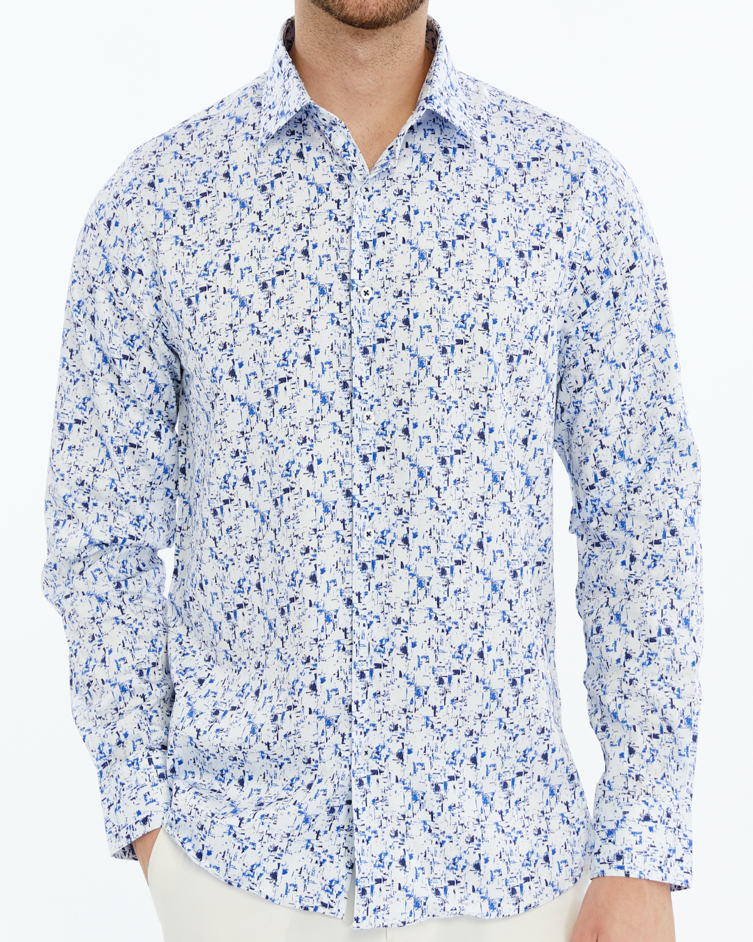 Man wearing a white shirt with blue floral pattern on a white background